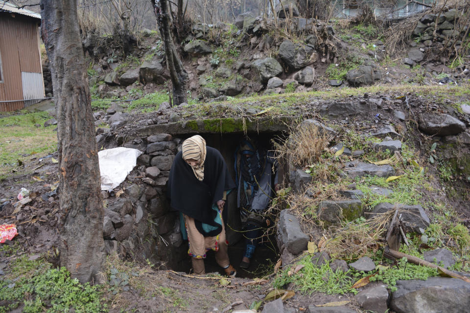 FILE - In this Feb. 26, 2019, file photo, Pakistani Kashmiri residents climb out of a bunker built outside their home in border town of Chakoti situated at the Line of Control in Pakistani Kashmir. The Line of Control, a highly militarized de facto border that divides the disputed region between the two nuclear-armed rivals India and Pakistan, and a site of hundreds of deaths, is unusually quiet after the two South Asian neighbors agreed in February, 2021, to reaffirm their 2003 cease-fire accord. (AP Photo/Abdul Razaq, File)