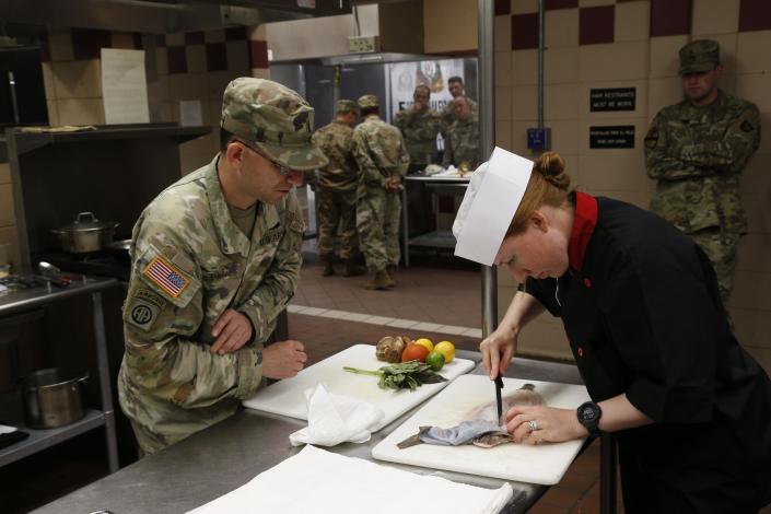 Senior food advisor Jason Page watches as captain Carol Jaksec filets a Dover Sole.