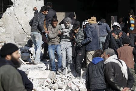 Residents help an injured man in a site hit by what activists said were airstrikes carried out by the Russian air force in the rebel-controlled area of Maaret al-Numan town in Idlib province, Syria January 9, 2016. REUTERS/Khalil Ashawi