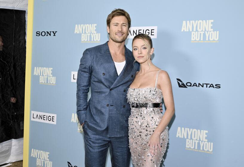 Actors Glen Powell, left, and Sydney Sweeney right embrace at the premiere of their film