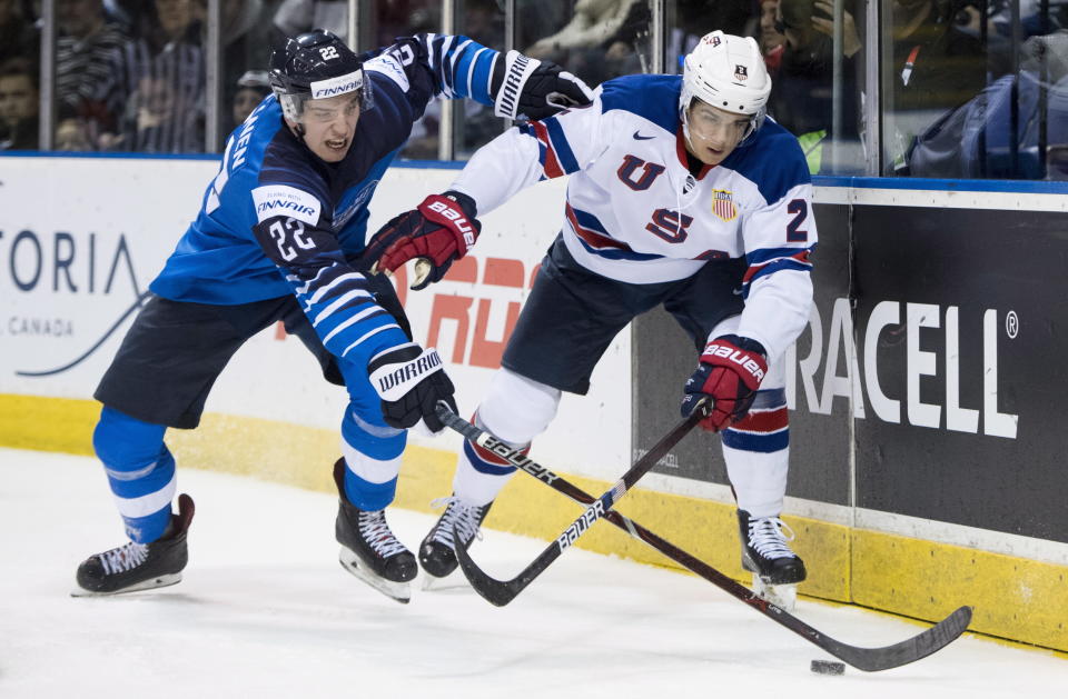 Finland's Santeri Virtanen (22) fights for control of the puck with United States' Jack St. Ivany (2) during the third period of a world junior hockey championships game in Victoria, British Columbia, Monday, Dec. 31, 2018. (Jonathan Hayward/The Canadian Press via AP)