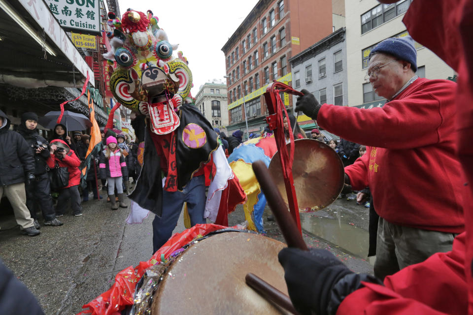 FILE - In this Feb. 8, 2016, file photo, a lion dancer is accompanied by a drummer and gong during a Lunar New Year celebration in New York's Chinatown neighborhood. The 2017 Lunar New Year holiday, celebrating the year of the rooster, begins Jan. 28. New York is one of a number of cities around the country that hosts parades with lion dancers. This year's procession in Manhattan's Chinatown is scheduled to take place Feb. 5. (AP Photo/Richard Drew, File)