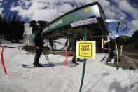 FILE - In this May 27, 2020, file photo, a sign reminds skiers to wait at socially-distant intervals before getting on a lift at the reopening of Arapahoe Basin Ski Resort, which closed in mid-March to help in the effort to stop the spread of the new coronavirus, in Keystone, Colo. The virus has created a number of new wrinkles for skiers and snowboarders to navigate as the winter sports season opens. (AP Photo/David Zalubowski, File)