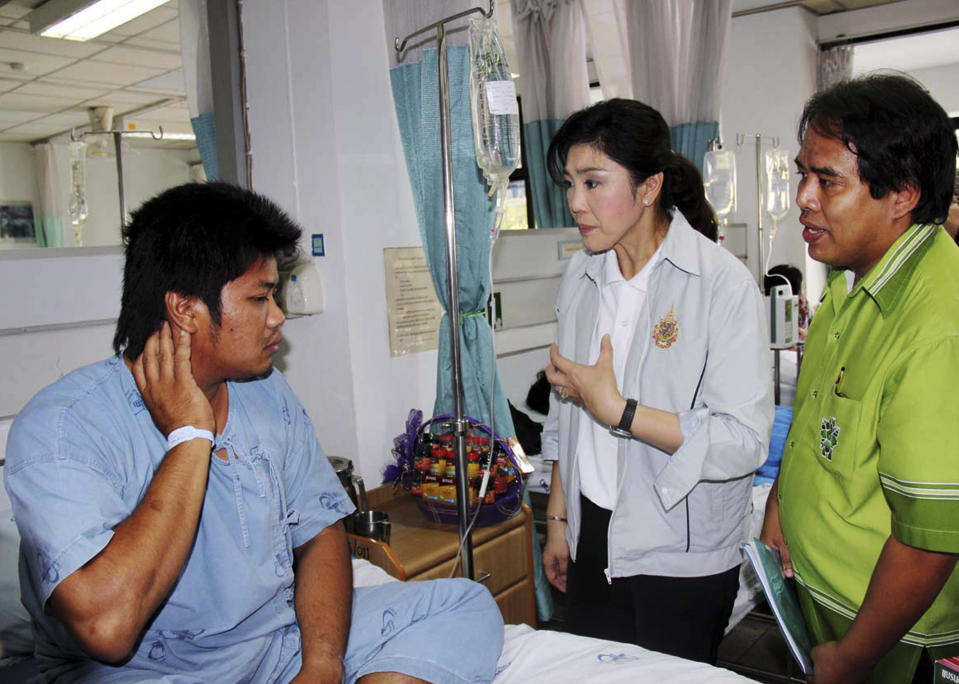 Thailand's Prime Minister Yingluck Shinawatra, center, talks with an injured worker, left, at a hospital following a factory fire in Rayong province, Thailand Sunday, May 6, 2012. A fire caused by explosions in one of the world's largest petrochemical industrial estates have killed 12 and injured more than 100 people in eastern Thailand. (AP Photo)