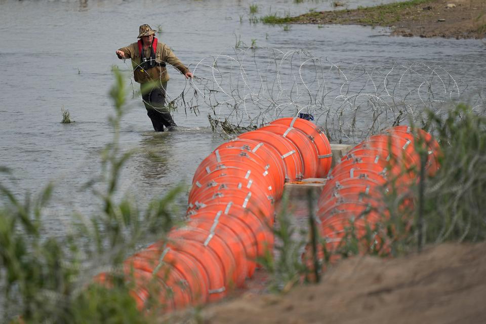 July 11, 2023: Workers assemble large buoys to be used as a border barrier along the banks of the Rio Grande in Eagle Pass , Texas. The floating barrier is being deployed in an effort to block migrants from entering Texas from Mexico.