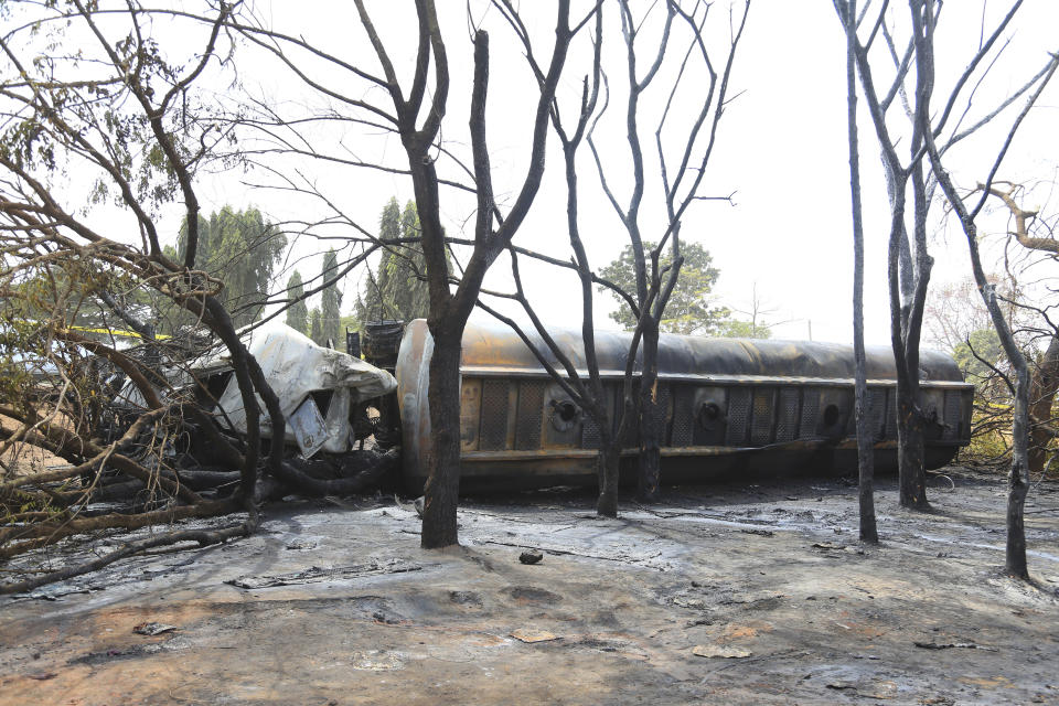 The wreckage of petrol tanker lies among burnt out trees in Morogoro Township about 200 km from Dar es Salaam, Saturday Aug. 10, 2019. A damaged tanker truck exploded in eastern Tanzania Saturday as people were trying to siphon fuel out of it, killing at least 62, in one of the worst incidents of its kind in the East African country. (AP Photo/ Khalfan Said)