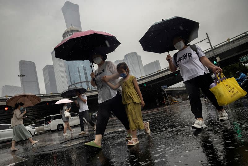 FILE PHOTO: People walk in the Central Business District on a rainy day, in Beijing