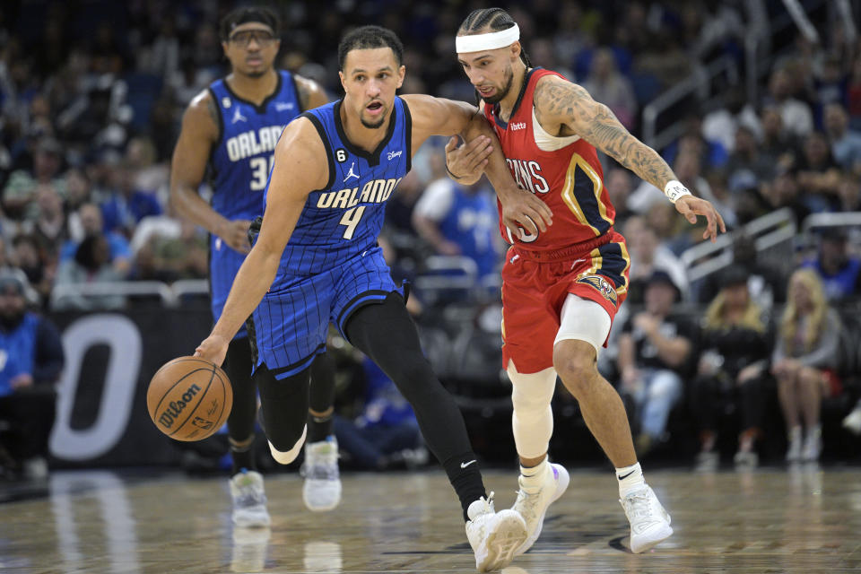 Orlando Magic guard Jalen Suggs (4) pushes the ball up the court as New Orleans Pelicans guard Jose Alvarado, right, defends during the first half of an NBA basketball game Friday, Jan. 20, 2023, in Orlando, Fla. (AP Photo/Phelan M. Ebenhack)