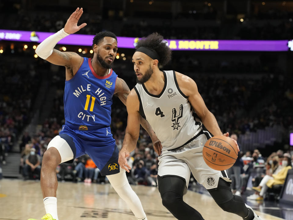 San Antonio Spurs guard Derrick White, right, is defended by Denver Nuggets guard Monte Morris during the first half of an NBA basketball game Friday, Oct. 22, 2021, in Denver. (AP Photo/David Zalubowski)