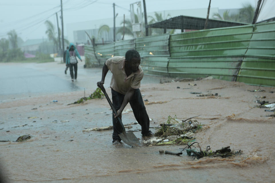 A man clears rubble on a street, in Pemba, on the northeastern coast of Mozambique, Sunday, April, 28, 2019. Serious flooding began on Sunday in parts of northern Mozambique that were hit by Cyclone Kenneth three days ago, with waters waist-high in areas, after the government urged many people to immediately seek higher ground. Hundreds of thousands of people were at risk. (AP Photo/Tsvangirayi Mukwazhi)
