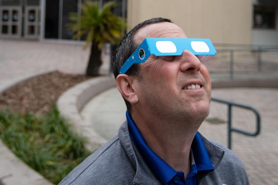 Alan Hanstein, executive director of the Challenger Learning Center, uses solar eclipse glasses to look directly at the sun Wednesday, March 13, 2024.