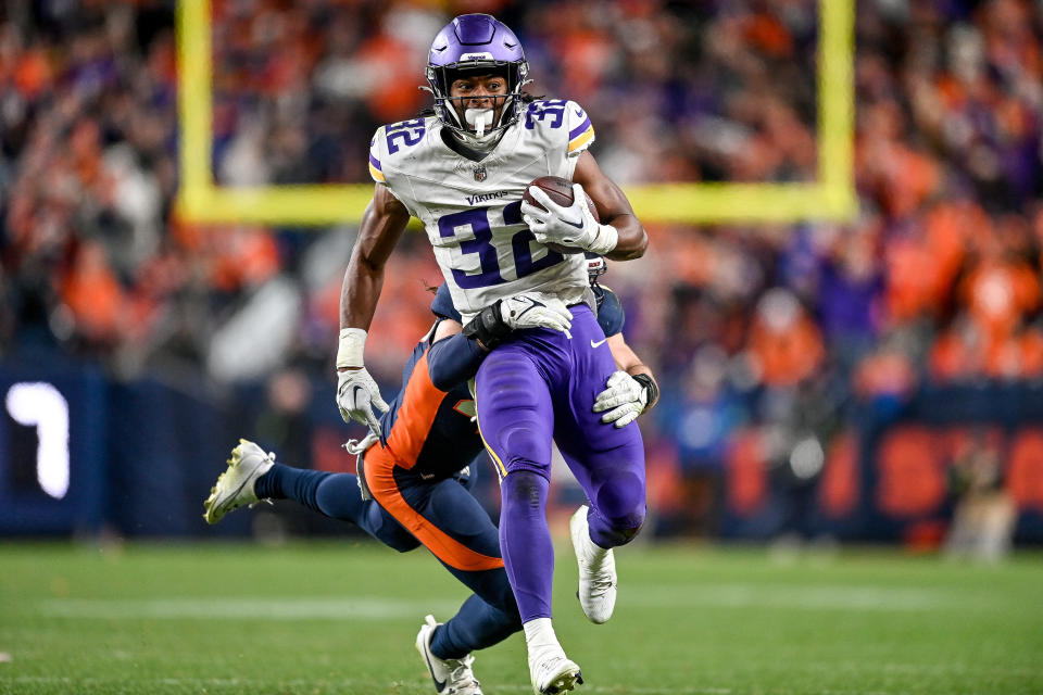 DENVER, COLORADO - NOVEMBER 19:  Ty Chandler #32 of the Minnesota Vikings carries the ball after a catch against the Denver Broncos in the fourth quarter at Empower Field at Mile High on November 19, 2023 in Denver, Colorado. (Photo by Dustin Bradford/Getty Images)