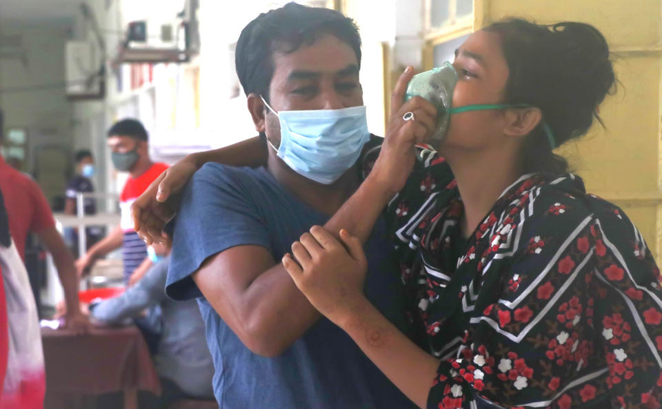 A man assists a patient facing difficulties in breathing at the Medical College Hospital in Rajshahi, 254 kilometers (158 miles) north of the capital, Dhaka, Bangladesh, June 16, 2021. Rajshahi has become one of the latest hotspots for the deadlier delta variant of the coronavirus. Bangladeshi authorities are increasingly becoming worried over the quick spread of coronavirus in about two dozen border districts close to India amid concern that the virus could devastate the crowded nation in coming weeks. (AP Photo/ Kabir Tuhin)