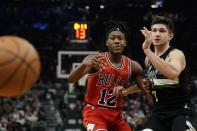 Chicago Bulls' Ayo Dosunmu and Milwaukee Bucks' Grayson Allen go after a loose ball during the first half of an NBA basketball game Friday, Jan. 21, 2022, in Milwaukee. (AP Photo/Morry Gash)