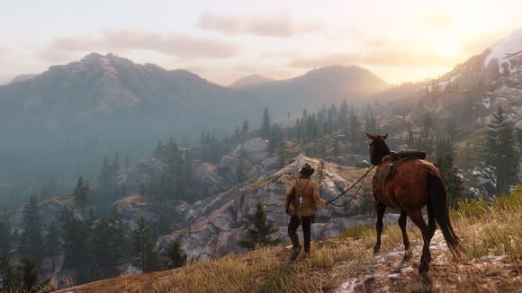 Man walking horse over beautiful, rugged terrain in screen shot from Red Dead Redemption 2.