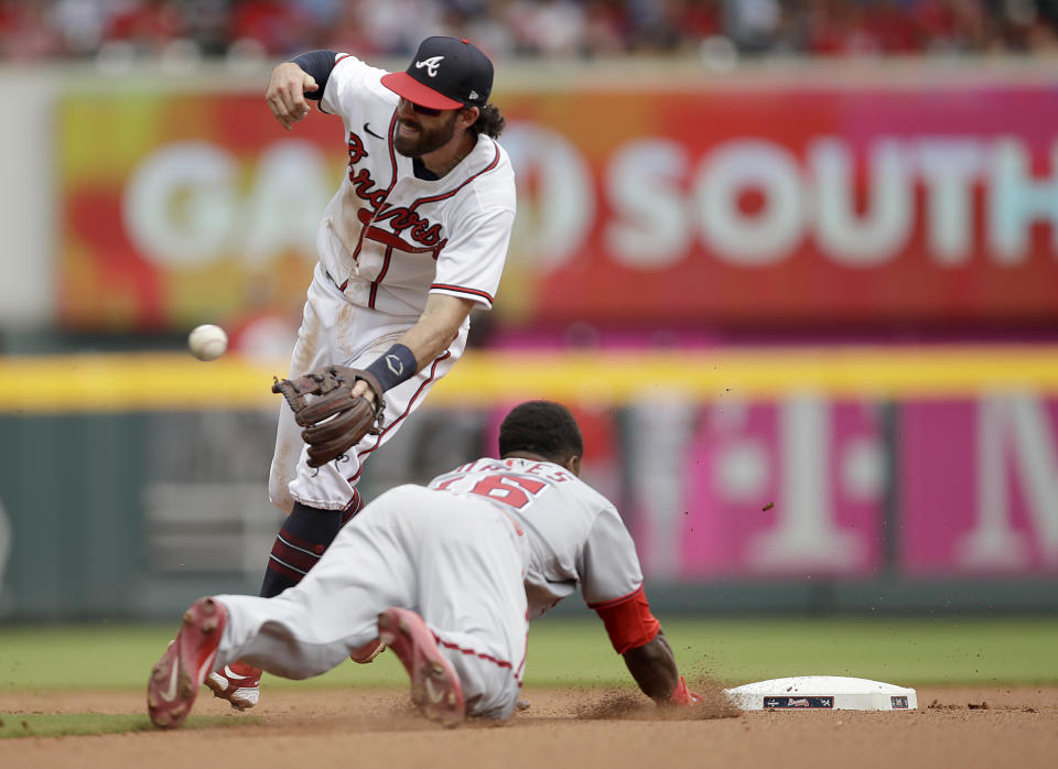 Washington Nationals' Victor Robles steals second base beneath Atlanta Braves' Dansby Swanson in the seventh inning of a baseball game, Sunday, July 10, 2022, in Atlanta. (AP Photo/Ben Margot)