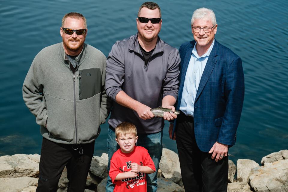 Jeff Miller, Mitch Pace, Jan McInturf, and Cruz Pace, 3, pose with a rainbow trout, Thursday, April 27 at the Tuscora Park pond in New Philadelphia. Fish were delivered to stock the pond in anticipation of the first ever trout derby there.