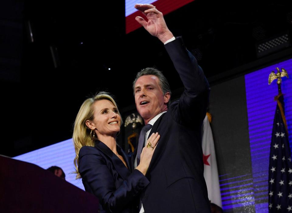 Gavin Newsom and his wife Jennifer Siebel Newsom wave to supporters during election night event on November 6, 2018 in Los Angeles, California (Getty Images)