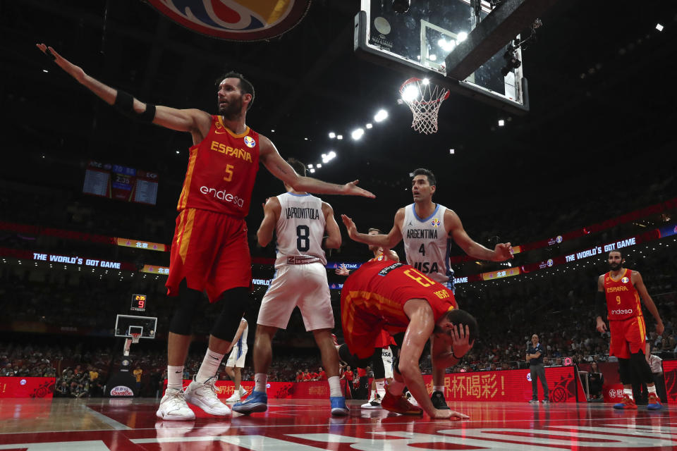 Spain's Marc Gasol center tumbles as teammate Rudy Fernandez, at left, and Argentina's Luis Scola, center in white, react during the final of the FIBA Basketball World Cup held at the Cadillac Arena in Beijing, Sunday, Sept. 15, 2019. (AP Photo/Ng Han Guan, Pool)