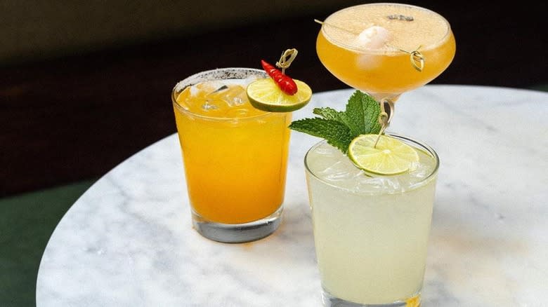 three orange and yellow cocktails