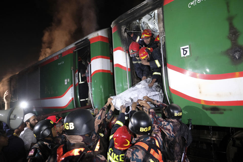 Security officers carry the body of a victim of a passenger train fire at Gopibagh in Dhaka, Bangladesh, Friday, Jan. 5, 2024. A fire on a moving passenger train in Bangladesh's capital on Friday night left at least four people dead and several others injured, ahead of Sunday's parliamentary election. (AP Photo/Mahmud Hossain Opu)