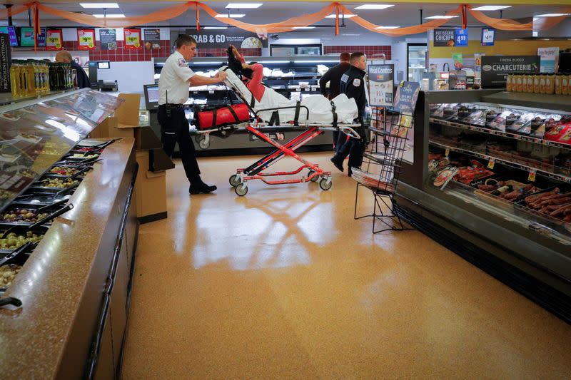 FILE PHOTO: Cataldo Ambulance medics Ricky Cormio (L) and Luke Magnant take a 40-year-old woman out of a grocery store where she was found unresponsive in the store's bathroom after overdosing on opioids in the Boston suburb of Malden