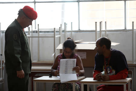 A Venezuelan soldier prepares to cast his vote at a polling station during the municipal legislators election in Caracas, Venezuela December 9, 2018. REUTERS/Marco Bello