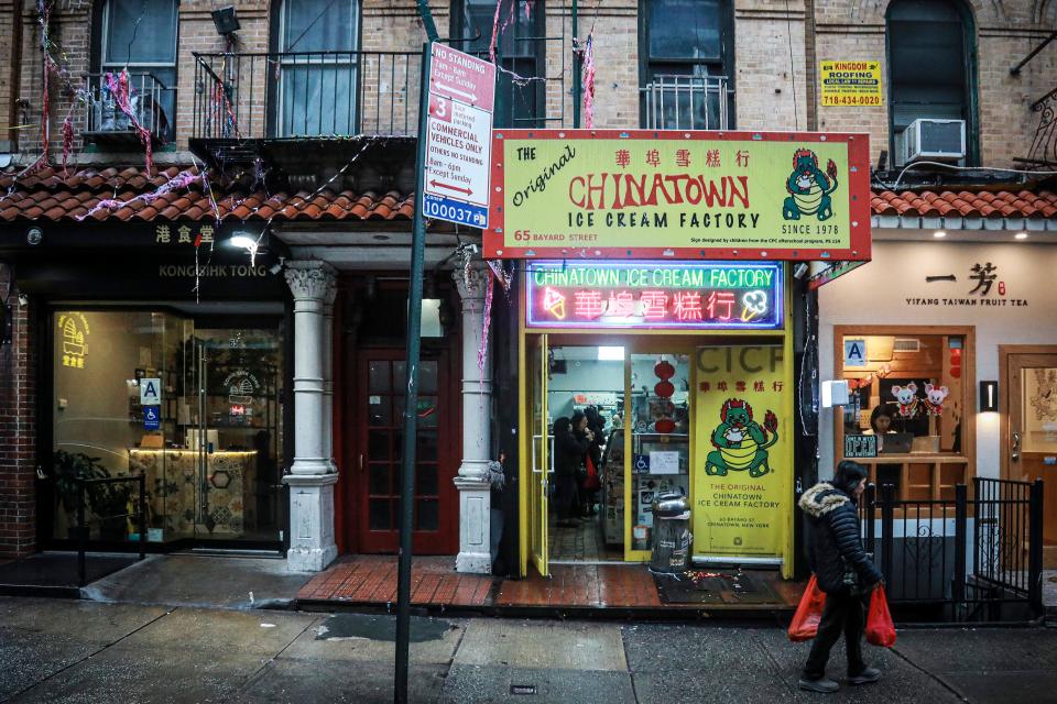 In this Feb. 13, 2020, photo, a woman walks by Chinatown Ice Cream Factory, a neighborhood fixture owned by Christina Seid and built by her father four decades ago in New York. "I’m probably more American than a lot of the people asking me about coronavirus," said Seid. "It’s a little annoying to be honest."