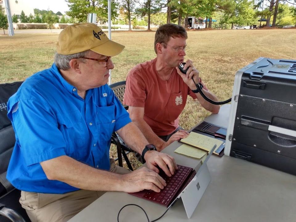 Thomas Gandy, right, uses traditional voice communications in the ham operator bands Saturday to communicate with a church in Pittsburgh, Pennsylvania, as Dr. Frank Howell, assistant director of the Delta Division of the American Radio Relay League, observes.