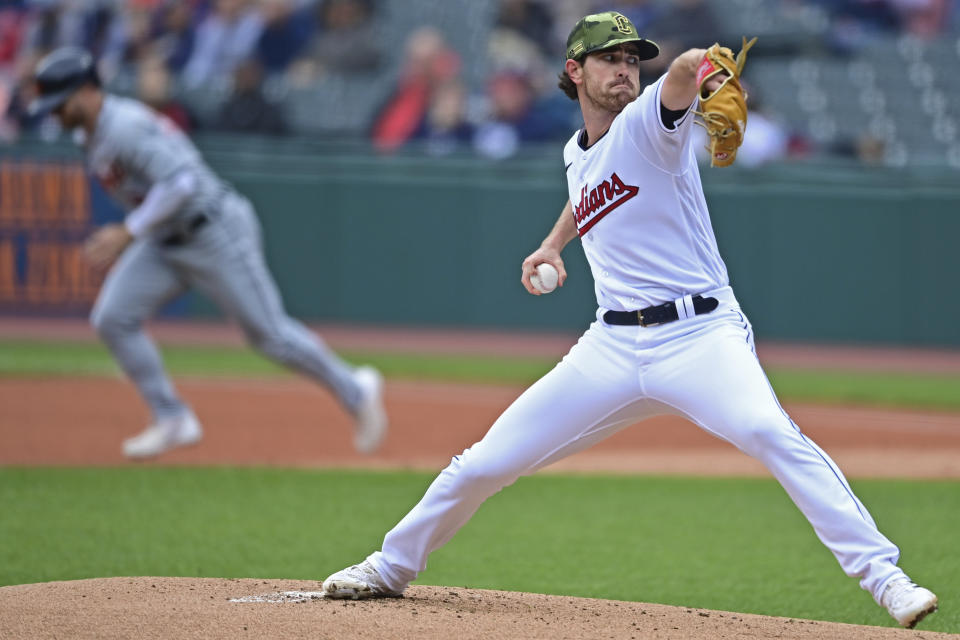 Cleveland Guardians starting pitcher Shane Bieber, right, delivers as Detroit Tigers' Robbie Grossman, back left, steals second base in the first inning of a baseball game, Sunday, May 22, 2022, in Cleveland. (AP Photo/David Dermer)