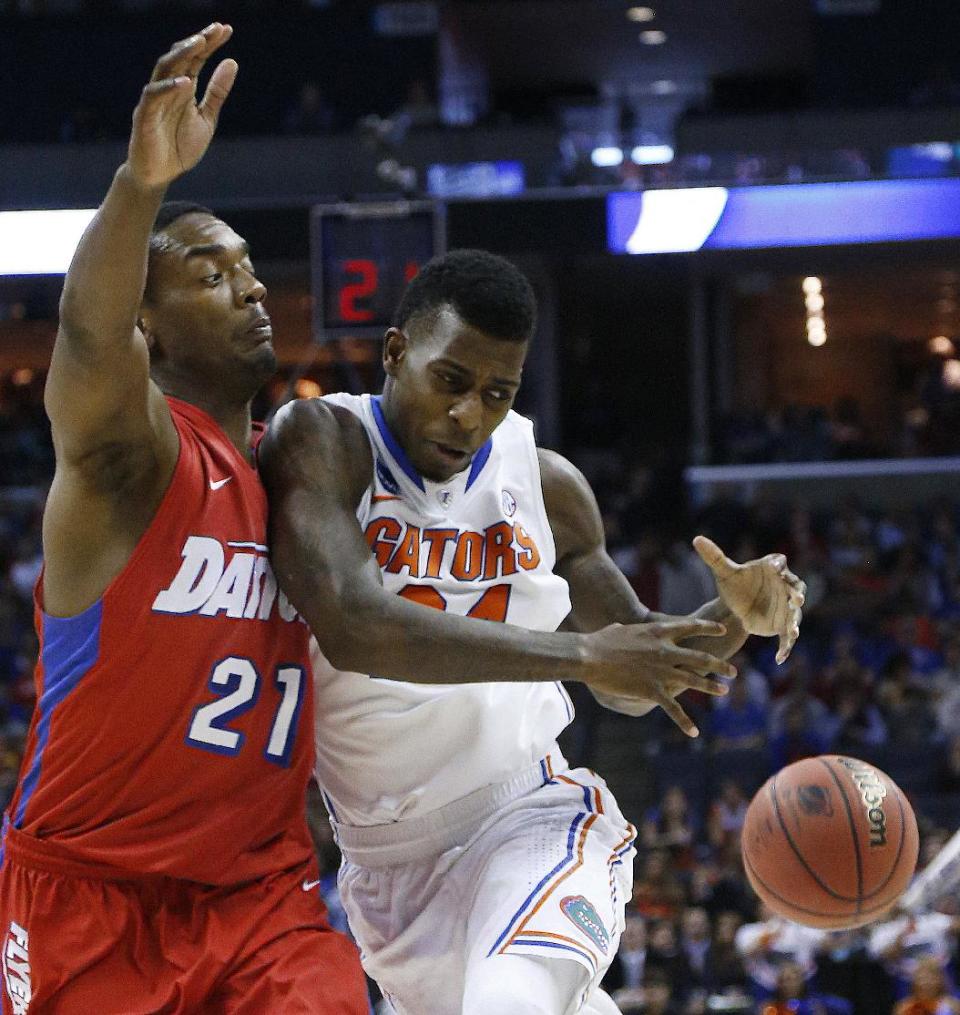 Florida forward Casey Prather (24) collides with Dayton forward Dyshawn Pierre (21) during the first half in a regional final game at the NCAA college basketball tournament, Saturday, March 29, 2014, in Memphis, Tenn. (AP Photo/Mark Humphrey)