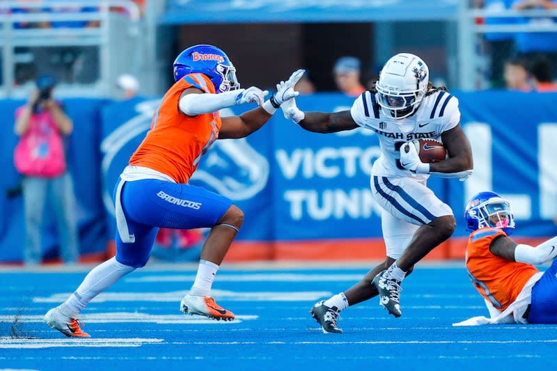 Utah State running back Rahsul Faison (3) stiff arms Boise State linebacker Andrew Simpson (10) on a run in the first half of an NCAA college football game, Saturday, Oct. 5, 2024, in Boise, Idaho. . (AP Photo/Steve Conner) | Steve Conner