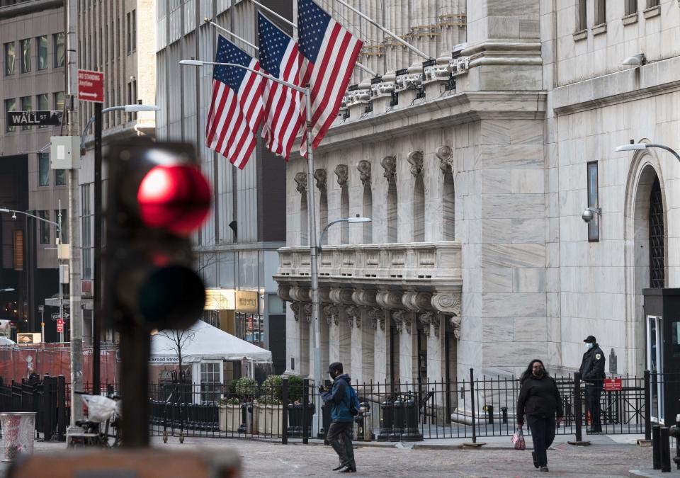 People walk past the New York Stock Exchange (NYSE) at Wall Street on March 23, 2021 in New York City. - Wall Street stocks were under pressure early ahead of congressional testimony from Federal Reserve Chief Jerome Powell as US Treasury bond yields continued to retreat. (Photo by Angela Weiss / AFP) (Photo by ANGELA WEISS/AFP via Getty Images)