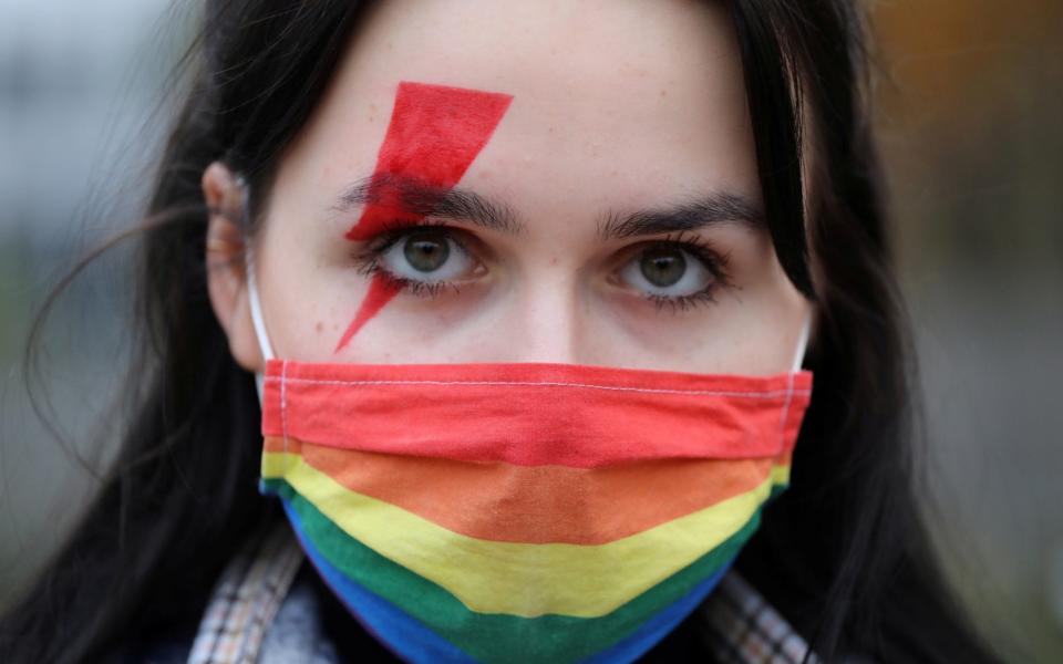 A woman wearing a rainbow-themed protective face mask attends a protest against the ruling by Poland's Constitutional Tribunal that imposes a near-total ban on abortion, in front of the Parliament in Warsaw, Poland -  Agencja Gazeta / REUTERS