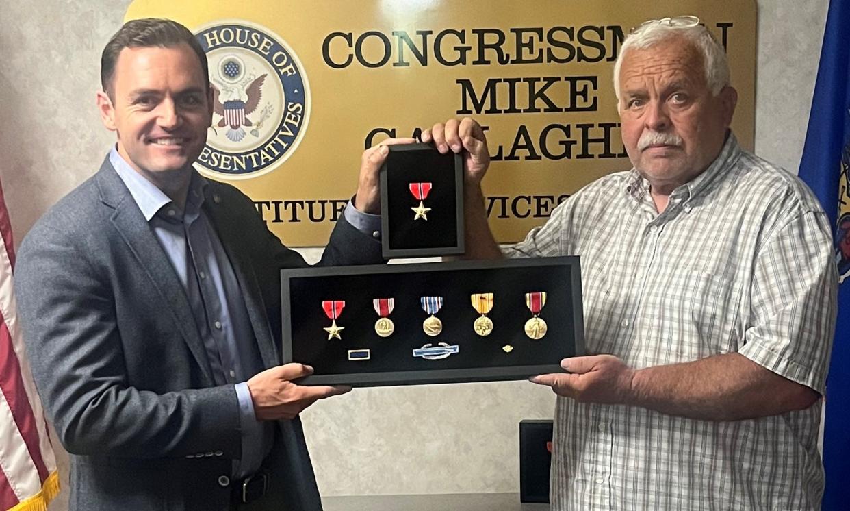 Rep. Mike Gallagher, left, presents Robert Jackson, son of World War II veteran Ray C. Jackson, with several posthumous medals for his service.