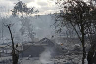 Smoke rises from smoldering houses in Kinma village, Pauk township, Magwe division, central Myanmar, Wednesday June 16, 2021. Residents said people are missing after military troops burned the village the night before. (AP Photo)