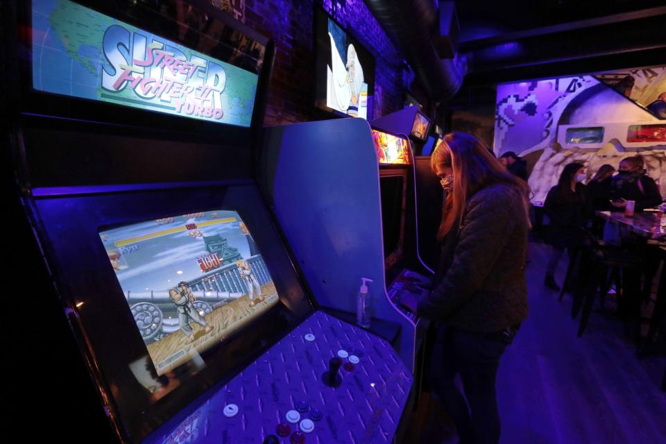 A woman enjoys playing a video game at the new Play Arcade Bar & Restaurant on Union Street in downtown New Bedford. 
[ PETER PEREIRA/THE STANDARD-TIMES/SCMG ]