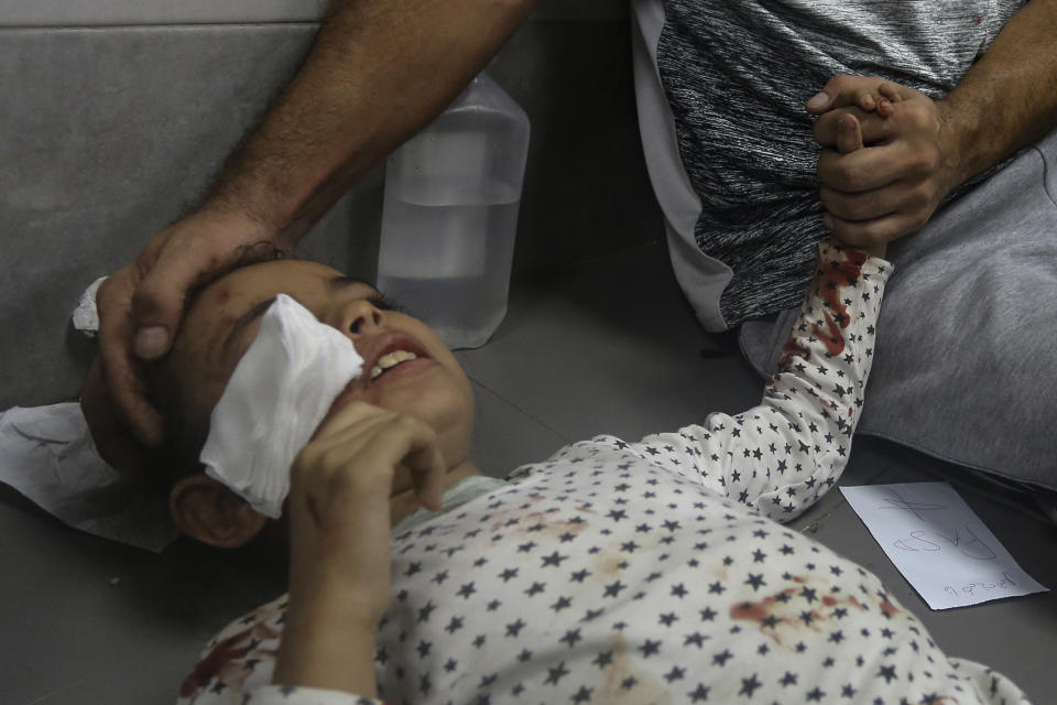 A Palestinian man holds the hand of his wounded daughter at the al-Shifa hospital, following Israeli airstrikes on Gaza City, central Gaza Strip, Monday, Oct. 23, 2023. (AP Photo/Abed Khaled)