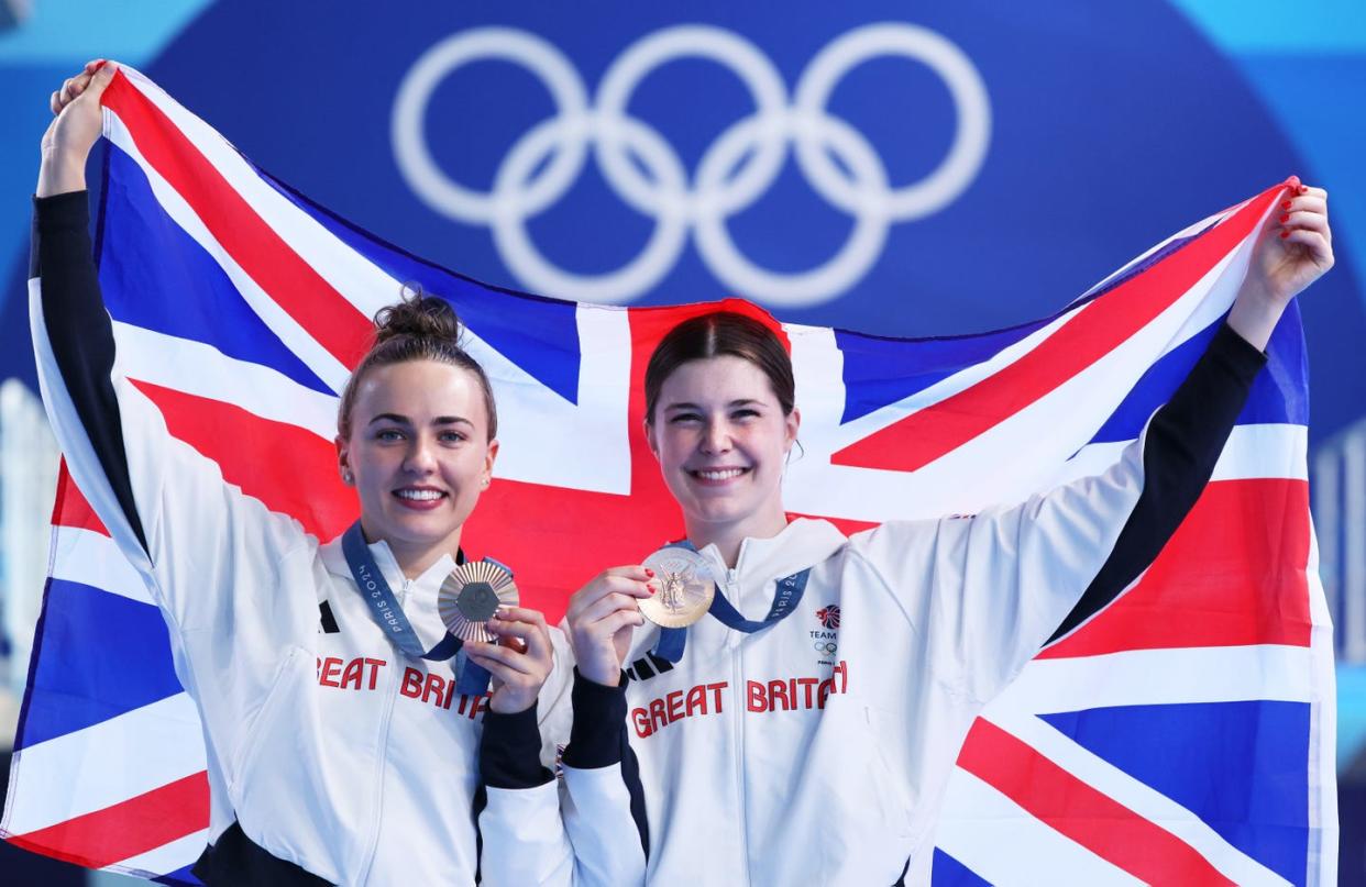 lois toulson and andrea spendolini sirieix pose with their bronze medals while holding flag of great britain at the paris olympics 2024