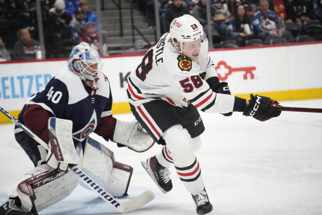 Chicago Blackhawks right wing MacKenzie Entwistle, right, looks for the puck as Colorado Avalanche goaltender Alexandar Georgiev, left, defends in the second period of an NHL hockey game Monday, March 20, 2023, in Denver. (AP Photo/David Zalubowski)