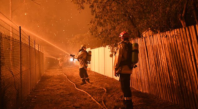 Firefighters fight flames close to homes in Corryton Court, Wattle Grove in Sydney, on Saturday. Source: AAP