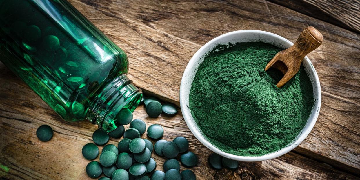 spirulina powder and pills shot from above on wooden table