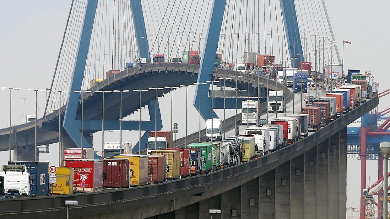 Mit Containern beladene Lastwagen stauen sich auf der Köhlbrandbrücke im Hamburger Hafen.