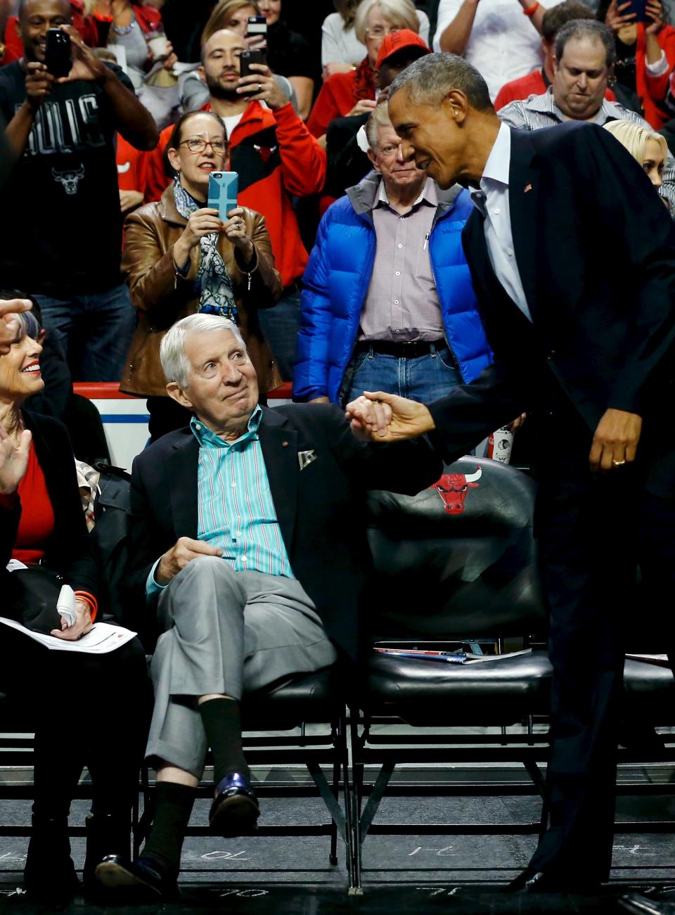 U.S. President Barack Obama (R) greets fans as he attends an NBA opening night game between the Cleveland Cavaliers and the Chicago Bulls in Chicago October 27, 2015. Earlier Tuesday Obama delivered remarks at an International Association of Chiefs of Police (IACP) conference and attended Democratic Party events in Chicago. REUTERS/Jonathan Ernst