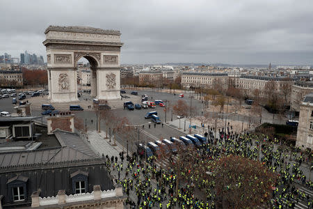 General view of protesters wearing yellow vests who gather on the Champs-Elysees Avenue and face off with gendarmes who block access to the Arc de Triomphe during a demonstration by the "yellow vests" movement in Paris, France, December 8, 2018. REUTERS/Benoit Tessier