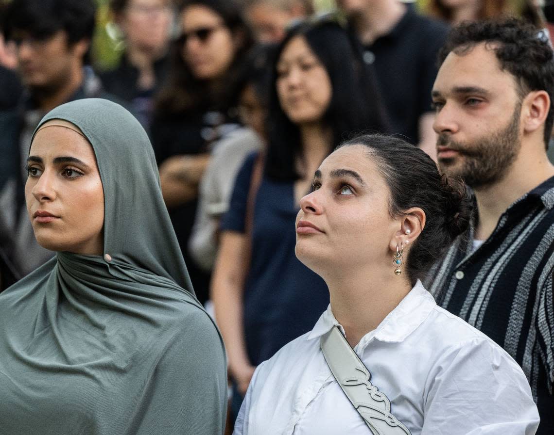 Sara Halabi Hakim, left, and her sister Amanda pay tribute to childhood friend Karim Abou Najm with members of the Davis community on on Monday, the one year anniversary of his death in Sycamore Park.