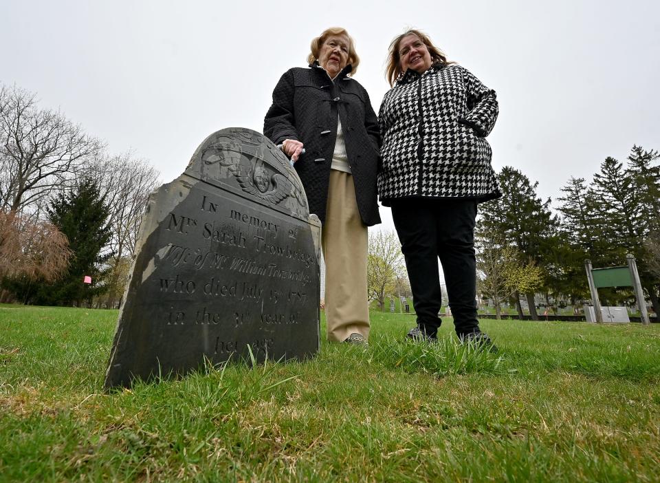 From left, Cookie Nelson and Janet Parent at one of two gravestones from the 1700s that were unearthed at Hope Cemetery.