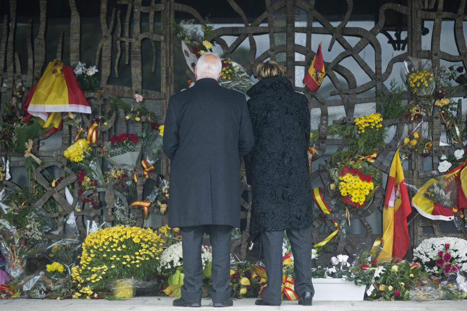 FILE - In this file photo dated Wednesday Nov. 20, 2019, a couple stand in front of a shrine with flowers and Spanish flags marking the 44th anniversary of the death of Spanish dictator Gen. Francisco Franco at the Mingorrubio's cemetery on the outskirts of Madrid, before the remains of Franco were exhumed from the grandiose Valley of the Fallen mausoleum and reburied in the small family crypt in Mingorrubio. The legacy of the dictator who ruled Spain for 35 years is still a raw issue in the country. The death of George Floyd at the hands of police and Minneapolis, USA, has sparked a re-examination of injustices and inequalities in the fabric of many societies, often symbolized in statues of historical figures have become the focus of protest around the world. (AP Photo/Paul White, FILE)