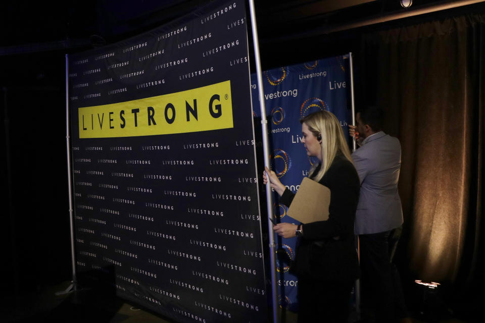 In this Monday, Feb. 3, 2020 photo, Livestrong logo backdrops are seen at an event in Austin, Texas. The Livestrong cancer charity is on a mission to reinvent itself. It has survived a dramatic fall in contributions and donations since founder Lance Armstrong's performance-enhancing drug scandal. (AP Photo/Eric Gay)