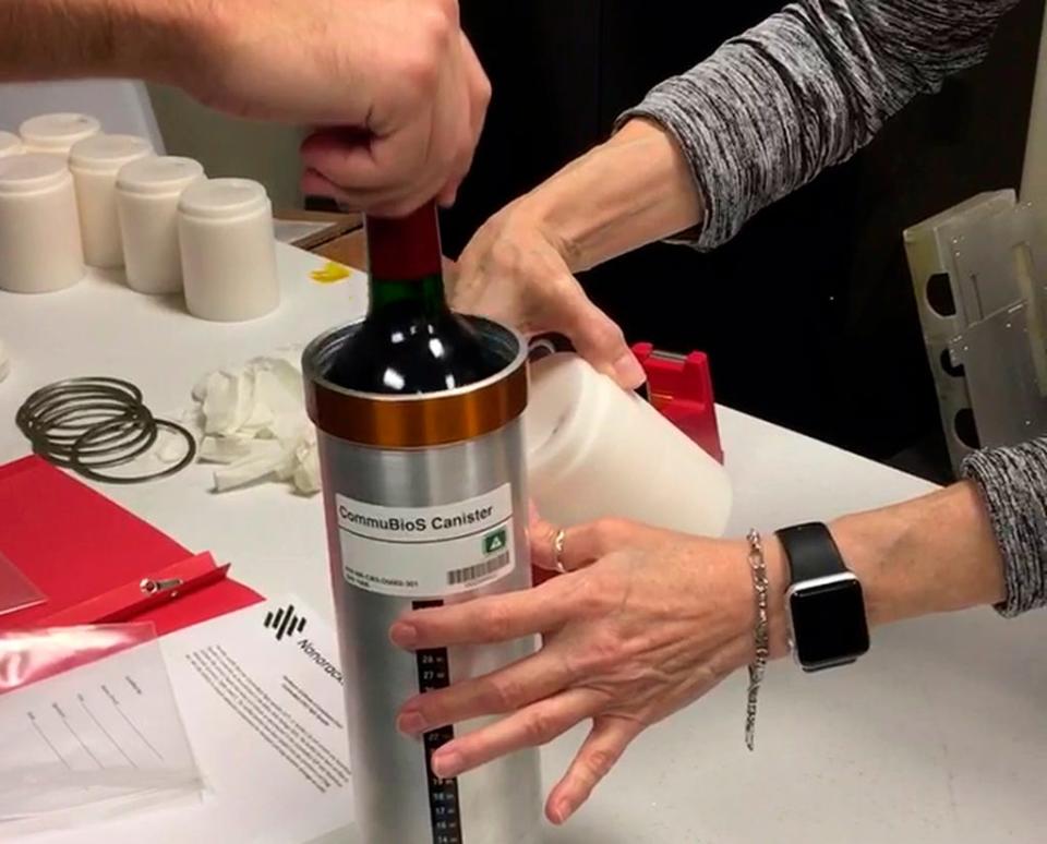 Researchers prepare bottles of French red wine to be flown from Wallops Island, Va., to the International Space Station In November 2019.